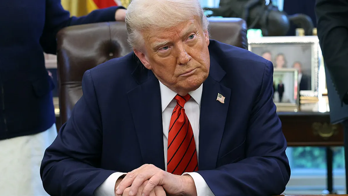 President Trump in the oval office of the white house as press looks on