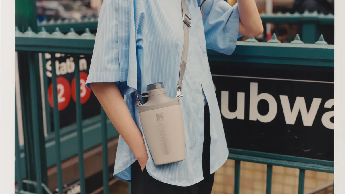 A person wearing a cross-body water bottle.